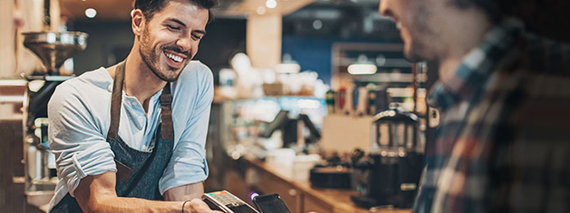 Hombre trabajando recibiendo un pago contactless