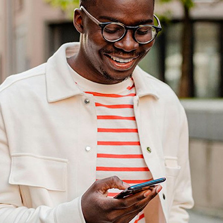 Hombre sonriendo mirando su smartphone