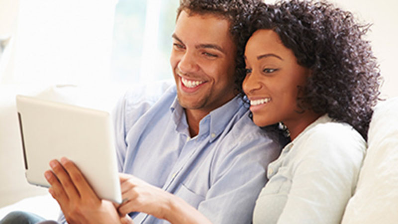 assigning-managing-800x450 pareja sonriendo frente a una tablet