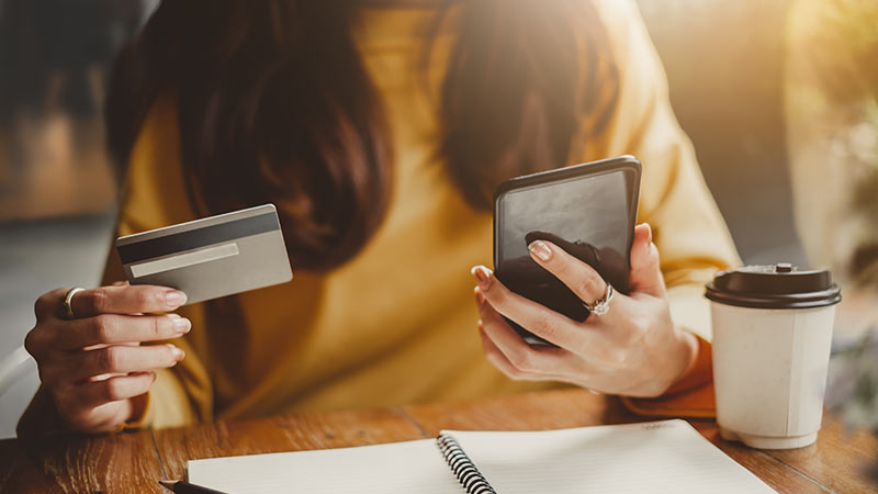 Mujer utilizado teléfono móvil y tarjeta de crédito