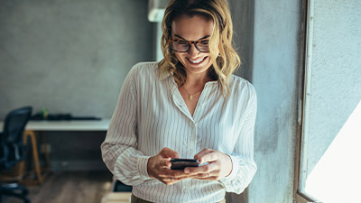 Mujer sonriente utilizando su celular