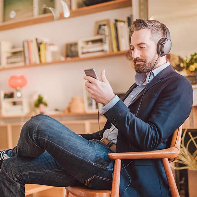 Hombre escuchando música y mirando su celular